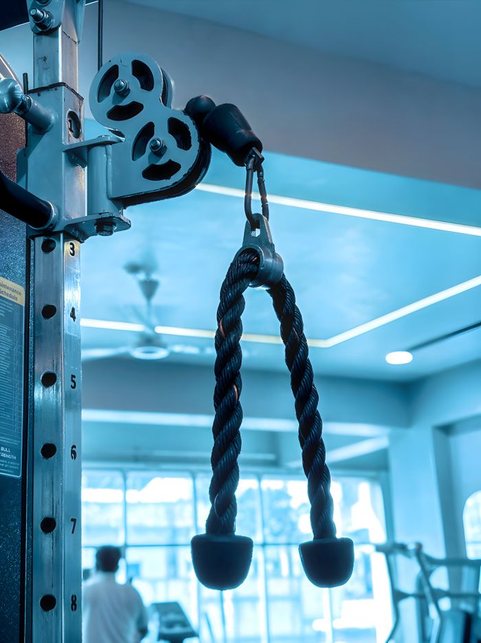 about-img-01 Close-up of gym equipment with rope pulley, fitness background in modern gym.